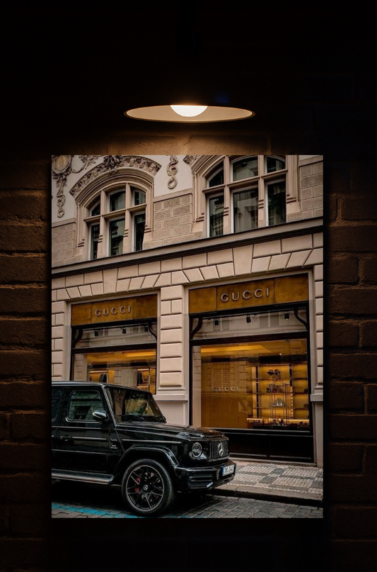 Gucci store front with a black G-Wagon  in front, framed against a dark background printed on velvet